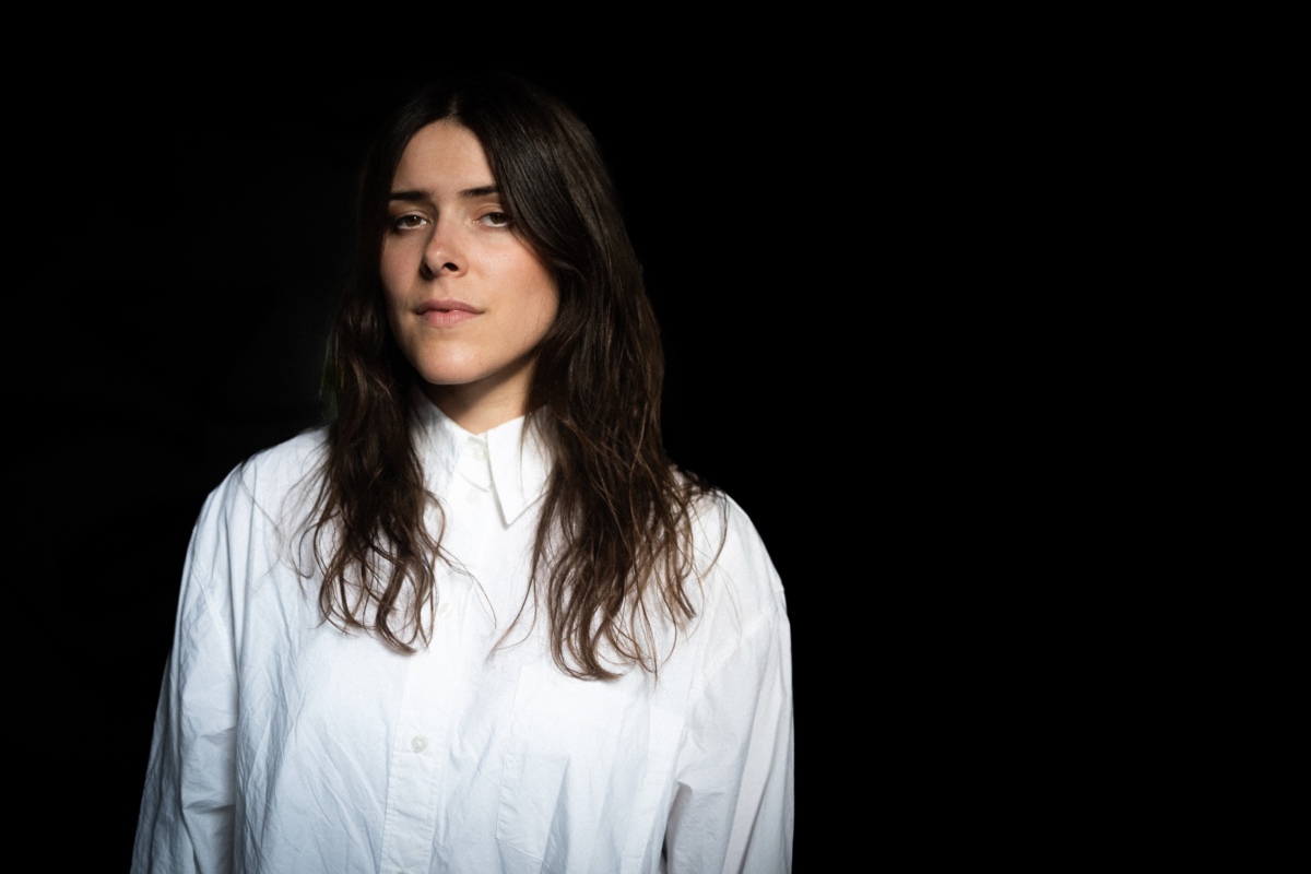 BARANY steht vor einem schwarzen Hintergrund in weissem Hemd und schaut etwas müde und mysteriös in die Kamera