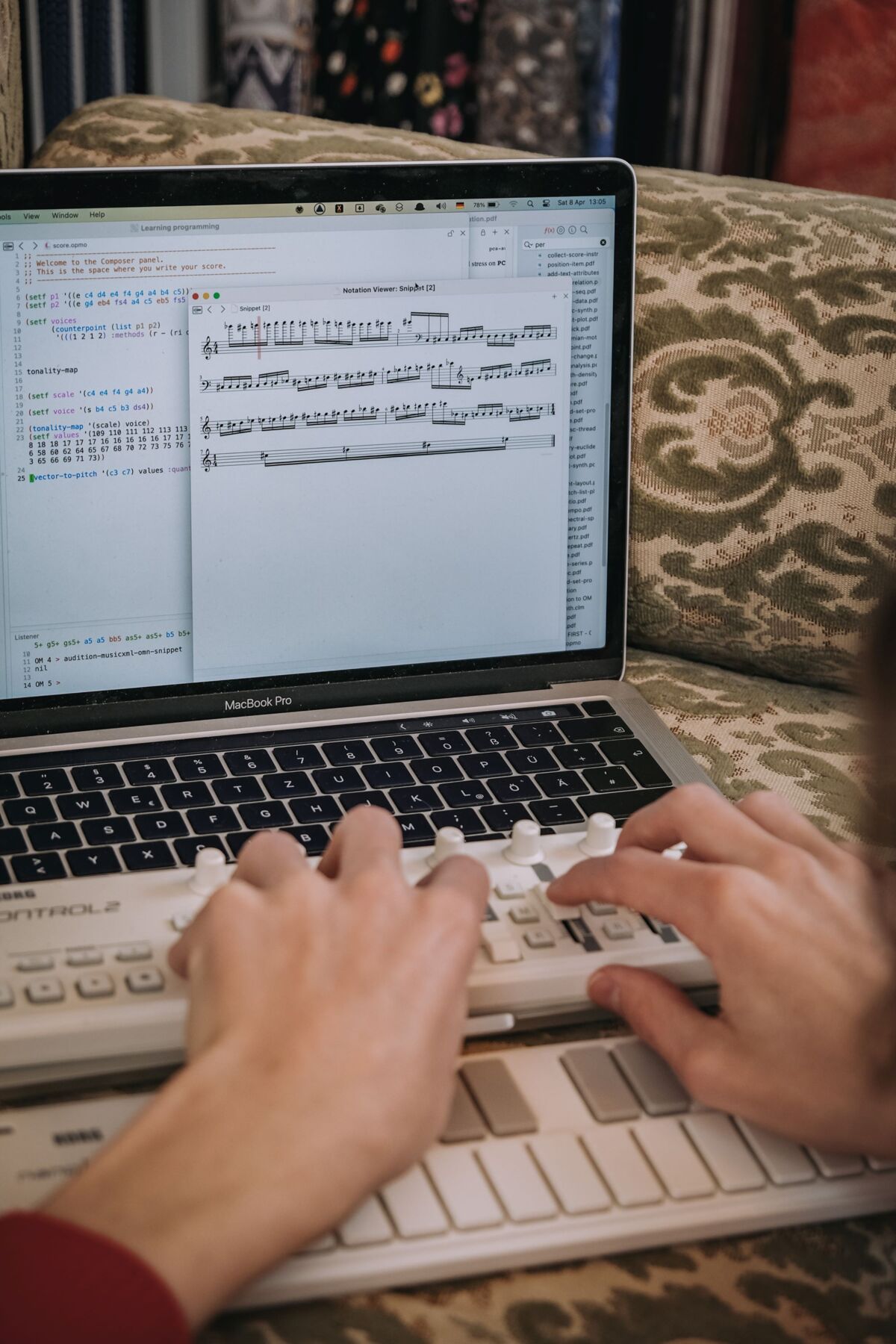 Vili Polajnar sitzt an seinem laptop, auf dem ein Notenprogramm geöffnet ist, während er vor sich ein kleines Keyboard weitere Knöpfe für die Soundverstellung bedient