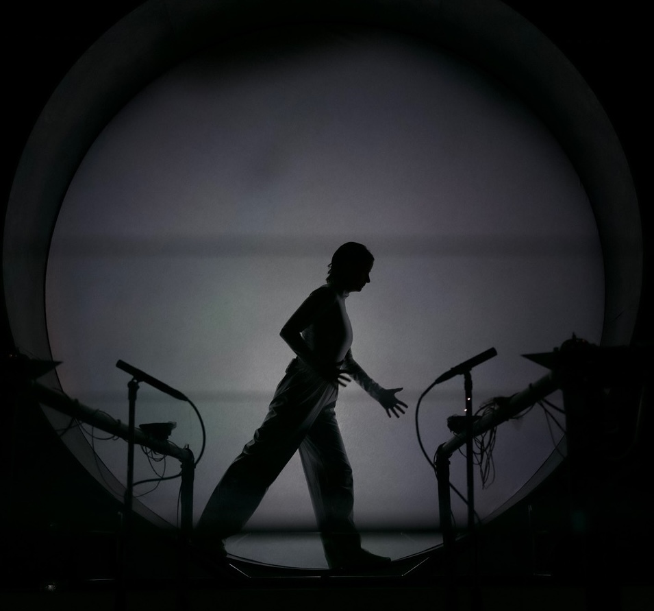 Foto der Silhouette einer Person in einer überdimensionalen Waschtrommel in schwarz weiss