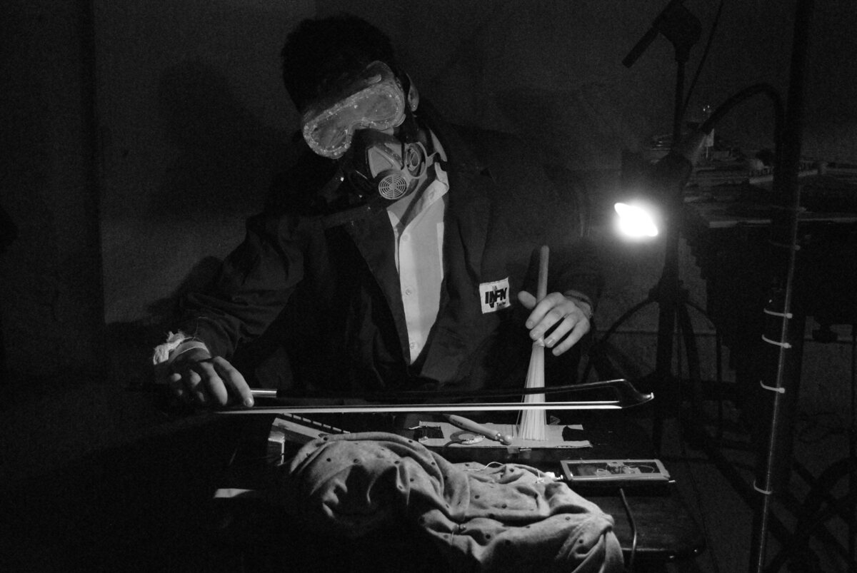 Foto von Stanislas Pili mit Maske und Instrument.